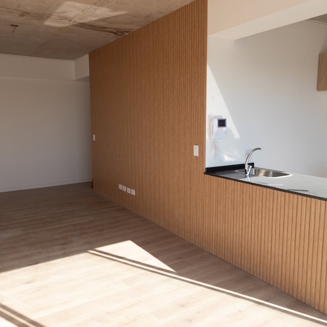 Cocina con isla y paneles de madera