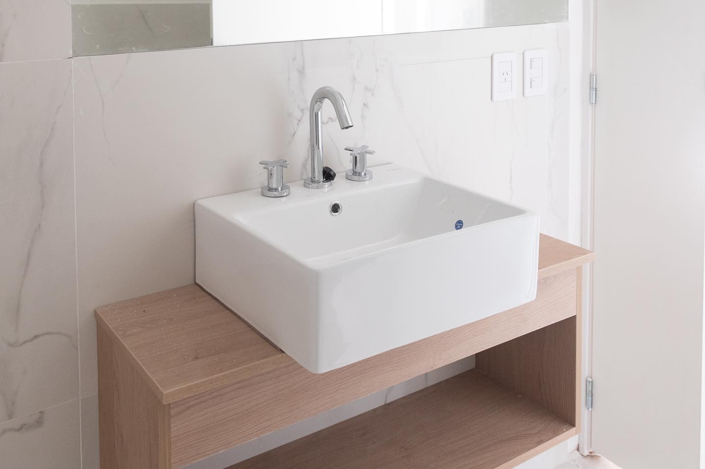 Baño con vanity de madera y mármol