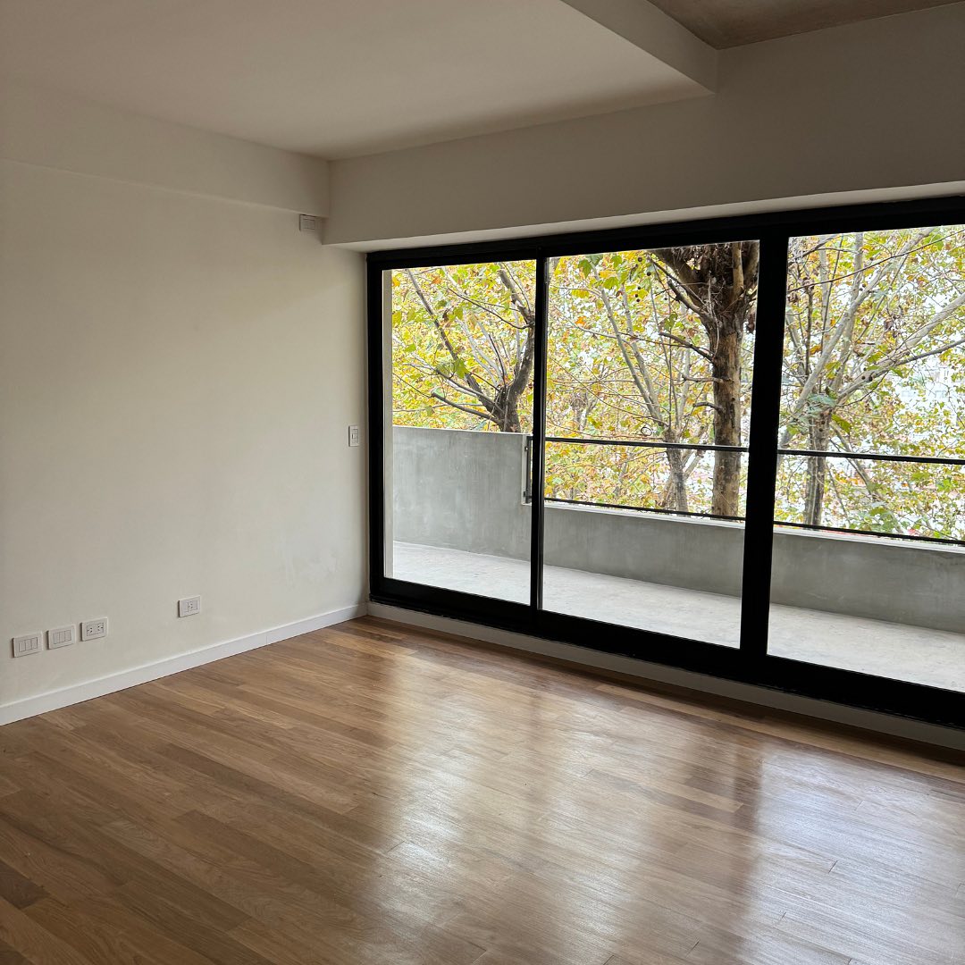 Living con piso de madera y balcón