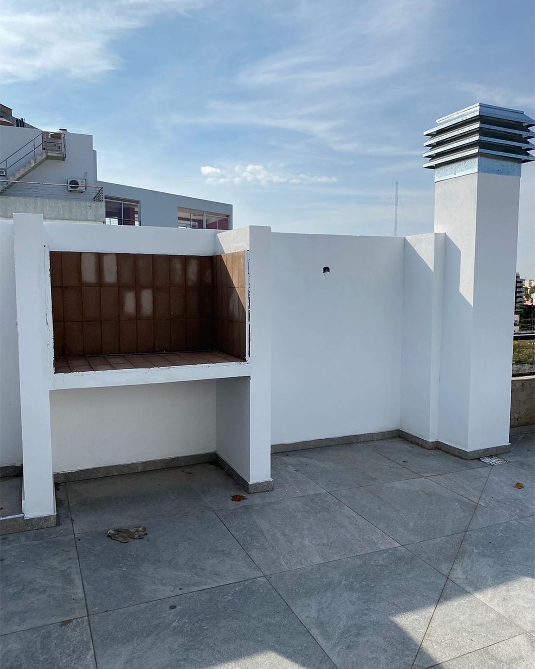 Terraza con parrilla y vistas al barrio